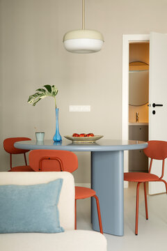 Modern Interior Design: Stylish Dining Area with Round Table and Orange Chairs in a Contemporary Apartment