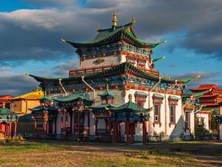 Obraz premium Vibrant Ivolginsky Datsan Buddhist monastery building under a cloudy sky showcasing colorful traditional architecture