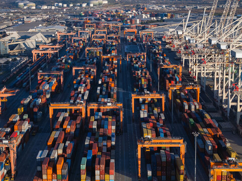 Cargo containers are organized in a shipping port with cranes for efficient freight transport and global trade management.