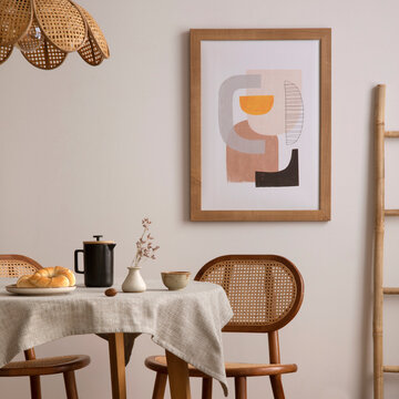 Minimalist dining room interior with framed artwork, wooden furniture, and breakfast items for a cozy home atmosphere