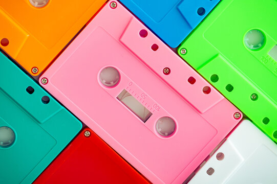 Colorful retro audio cassette tape pattern background with vibrant neon colors. Creative concept of vintage technology. Nostalgia aesthetic. Flat lay.