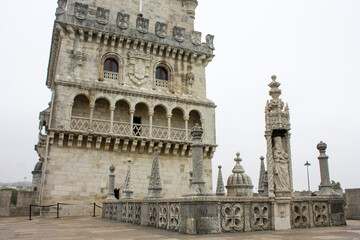 Obraz premium Lisbon, Portugal. Bastion terrace of the Torre de Belem (1514-1519) with the Gothic statue of Nossa Senhora da Boa Viagem and King Manuel I's royal coat of arms on the tower facade. Belem district