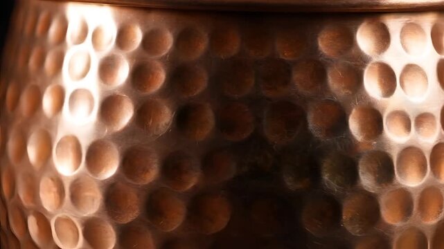Closeup of Hammered Copper Pot Texture with Reflective Light.
