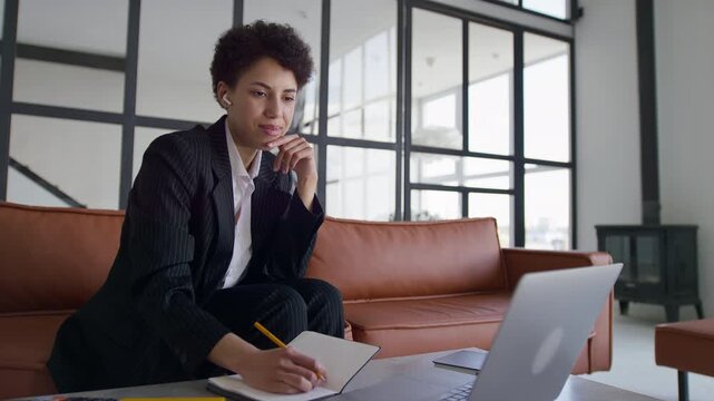 Businesswoman Taking Notes During Video Meeting