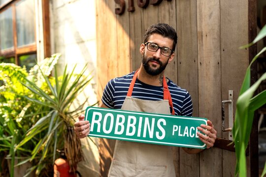 Man holding street sign outdoors.