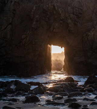 Detail of the Keyhole arch at Pfeiffer beach, with the setting sun to be just behind it.