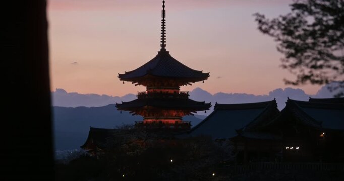 Beautiful silhouette of ancient Japanese temple as sky glows at dusk