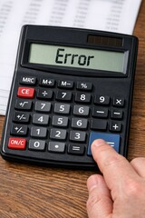 A calculator sits atop a wooden table