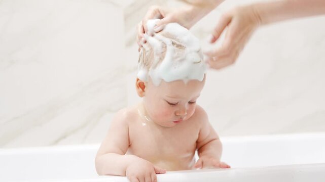 Baby enjoys bath time with soap and water fun
