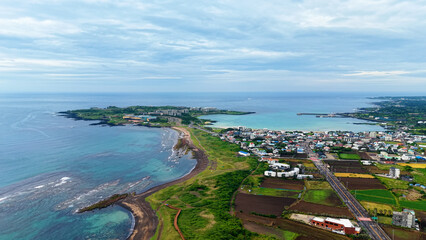 Aerial drone view of Seongsan Ilchulbong coastal village farmland and ocean landscape in Jeju Island South Korea © 은수 조