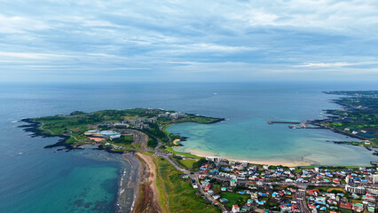 Aerial drone view of Seongsan Ilchulbong coastal village farmland and ocean landscape in Jeju Island South Korea © 은수 조