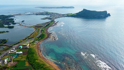 Aerial drone view of Seongsan Ilchulbong coastal village farmland and ocean landscape in Jeju Island South Korea © 은수 조