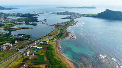 Aerial drone view of Seongsan Ilchulbong coastal village farmland and ocean landscape in Jeju Island South Korea © 은수 조