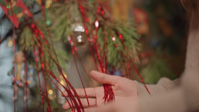 Holiday decorating activities. Decorating with lights and tinsel. Women embellishing space with festive ornaments. Joyful individuals decorating with sparkling decorations and luminous lights
