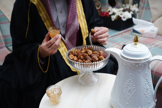 saudi man drinking arabic coffee with dates