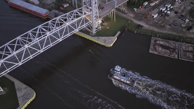 A ship passes under a bridge, shot from an overhead view.
