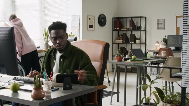 Medium full timelapse of African American male and Caucasian female software developers working together in technology startup office, writing code on computers, discussing project, proposing ideas