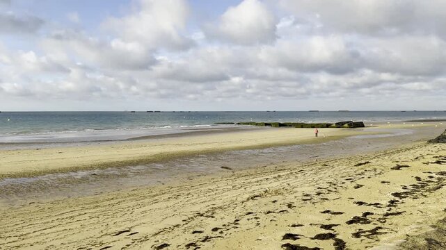 Landscape beauty shot shows coastline of the scenic French town of Arromanches in Normandy, at twilight.
