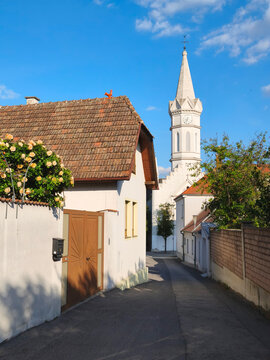 M&ouml;rbisch am See, Austria - 24 May 2026: Charming alley with church tower in M&ouml;rbisch am See