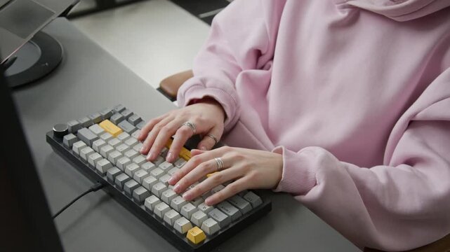 Tilting close-up of hands and face of tired gen Z Caucasian female programmer writing computer code on keyboard, then massaging neck, taking off glasses, suffering from poor concentration