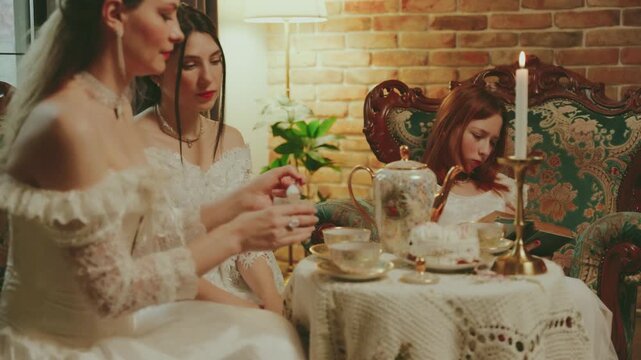 Female close-up holds sugar bowl in hands puts sugar into cup with teaspoon in hot tea golden mug set. Lady noble sitting on sofa coffee table girl rest in living room white vintage dress old style.