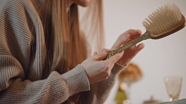 Examining ornate floral handle carefully. Hand examination of decorative wooden brush with floral design. Thorough review of wooden paddle brush focusing on handle craftsmanship and bristles