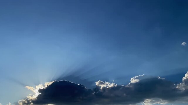 Sun rising above darkk cumulus clouds on blue sky. Nature, weather, air time lapse background