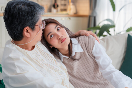 Happy Asian family looking at smart phone screen together inside home kitchen concept for social media content video creator digital influencer technology marketing lifestyle