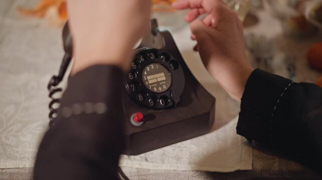 Precise manipulation of classic rotary dial. Deliberate and careful rotation of old fashioned telephone dial. Gently turning vintage rotary phone dial with focused and deliberate movements