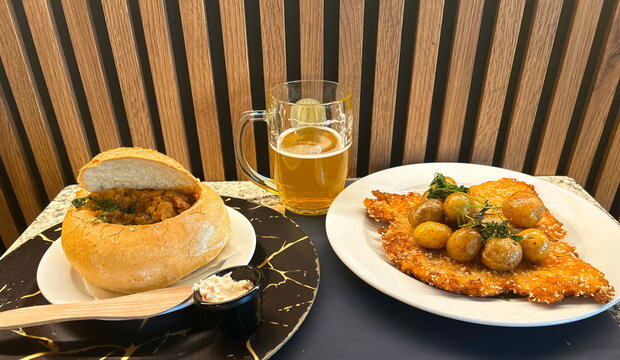 Polish menu: pork schnitzel with new potatoes and bigus in lard bread. Traditional dishes at the restaurant.