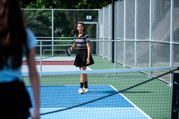 Obraz premium Female athletes playing pickleball and practicing for competition on an outdoor field
