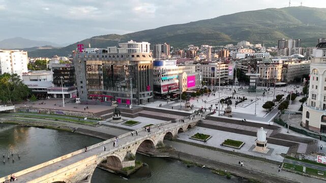 4K drone pull-away from Macedonia Square and historic Stone Bridge over Vardar River, Skopje, North Macedonia