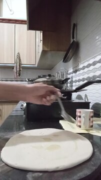preparing food,paratha making, roti preparation, indian bread, pakistani food, dough rolling, cooking process, homemade, traditional cooking, kitchen, chef hands, flatbread, layered paratha, ghee, foo