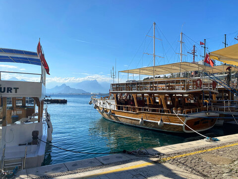 Traditional Turkish wooden gulet boats moored in Antalya marina with Taurus mountains