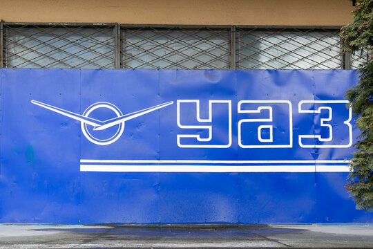 VLADIKAVKAZ, RUSSIA - MARCH 5, 2022: Corporate logo and sign of the Russian automotive brand UAZ on a blue metal fence on a city street