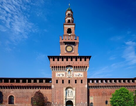 castello sforzesco filarete tower in milan italy showing the historic brick architecture and large clock face against a clear blue sky representing italian heritage and renaissance design