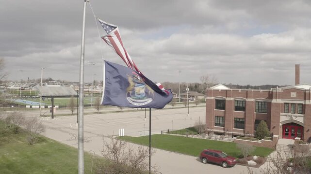 American and State Flags Waving in Wind with Brick Building Background