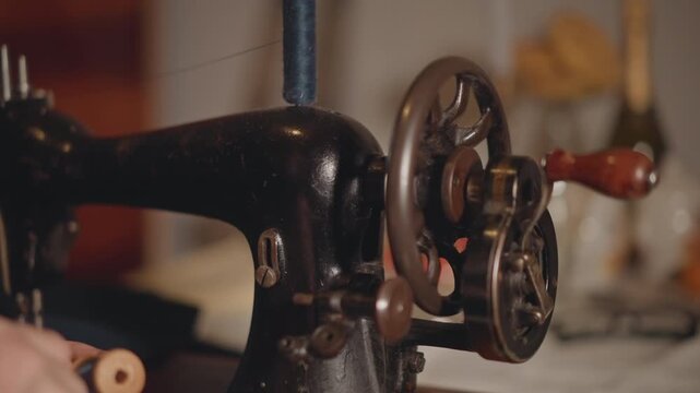 Antique sewing mechanism. Vintage sewing wheel and gear. Closeup of old sewing machine parts and detail. Detailed view of historical sewing device with textured surface and mechanisms