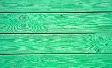 A close-up view of a textured green wooden surface, showcasing its natural grain and patterns. Ideal for backgrounds and design projects. © mocklyn