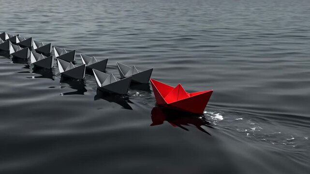 Red paper boat moves ahead of line of black paper boats on calm water. Simple design and smooth surface. Concept of teamwork, creativity, art in design, and innovation