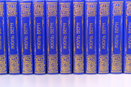 Moscow, Russia - May 11, 2026: A series of blue hardcover books by Jules Verne featuring gold lettering on the spines, neatly arranged in a row