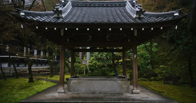 Smooth dolly in on old Japanese structure in lush area - wide shot