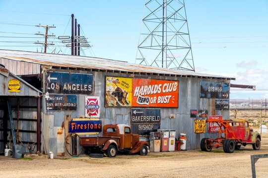 Rustic Route 66 roadside museum with old trucks and signs