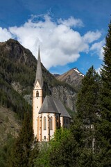 Fototapeta premium Church and village of Heiligenblut on the entrance to the mountain pass over the Grossglockner mountain group in Austria