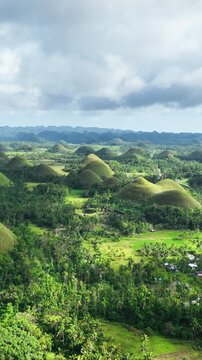 Aerial shot of the interesting rock formations called the Chocolate Hills on Bohol Island in the Philippines. Vertical Video.