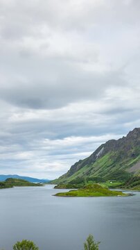 Time lapse of the clouds moving above the  amazing coastline and mountains of Norway. Vertical video.