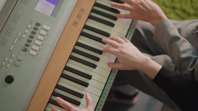 Overhead caucasian hands duet on keyboard practicing sync and rhythm, mentor coaching student for recital in bright living room, upbeat tempo and lively coordination, wrist technique and finger