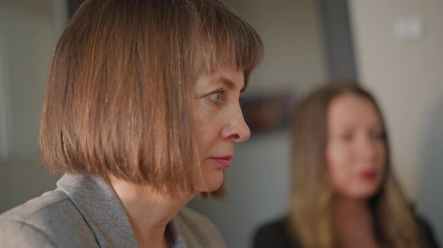 Focused music lesson woman teacher listening closely during vocal rehearsal mature instructor evaluates student performance in school classroom, serious expression, attentive posture, subtle emotion,
