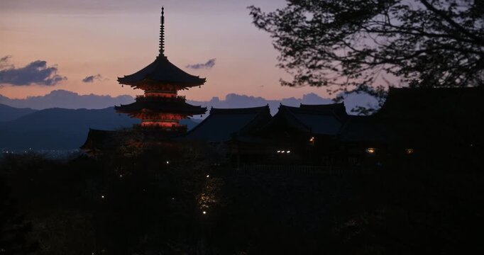 Slow motion silhouette of ancient Japanese temple at dusk - wide shot