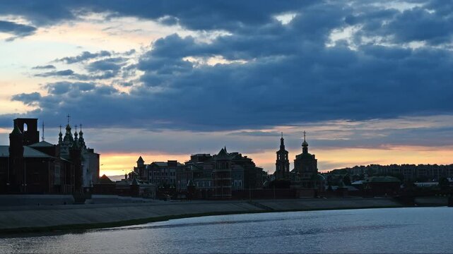 A picturesque embankment in the center of Yoshkar-Ola city at sunset with fabulous architecture and domes of the Annunciation Cathedral against a picturesque cloudy sky. Russia
